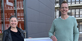 Eva Cendon (left) and Uwe Wilkesmann (right) next to the GfH poster.