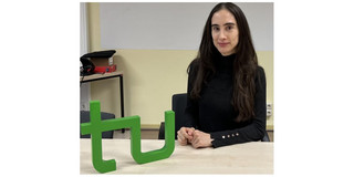 Portrait Klarissa Valero Riberio Saes, im Vordergrund das TU Logo Holzmodell