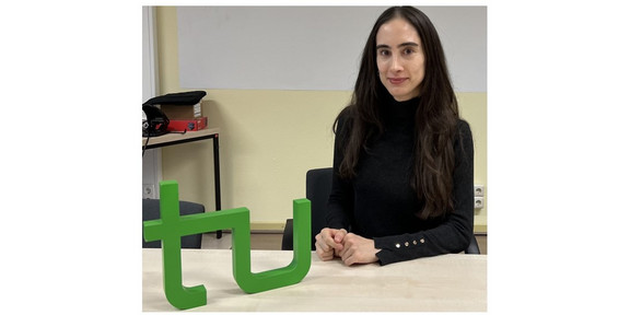Portrait Klarissa Valero Riberio Saes, im Vordergrund das TU Logo Holzmodell