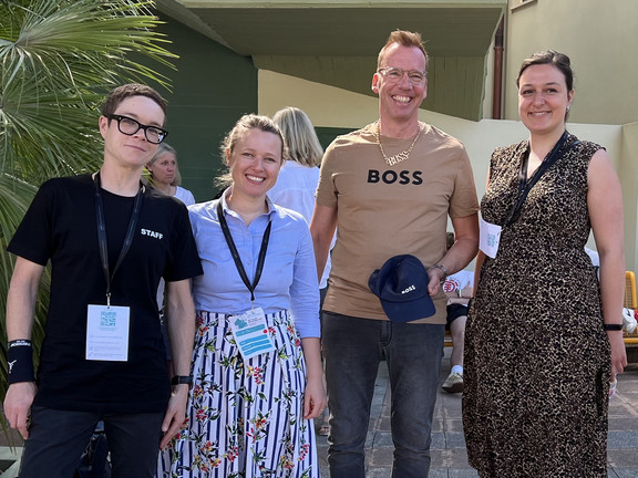 Sabine Lauer, Olga Wagner, Uwe Wilkesmann, Ronja Vorberg at the EGOS Conference. Wilkesmann wears a T-shirt, cap and necklace with the word "Boss" to match the title of the lecture.
