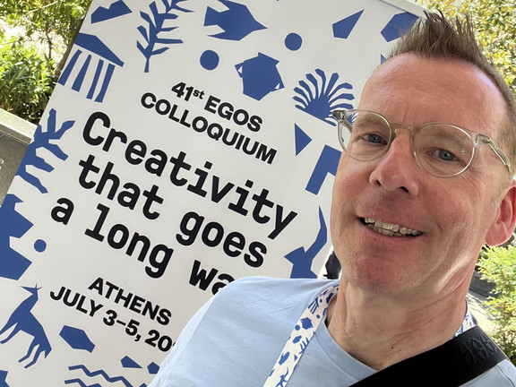 Uwe Wilkesmann in front of the EGOS conference poster