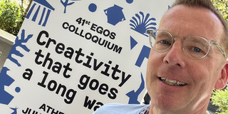 Uwe Wilkesmann in front of the EGOS conference poster