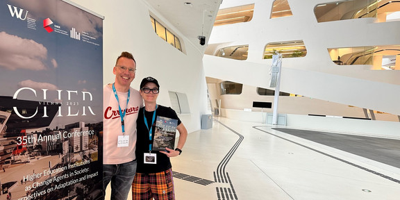 Uwe Wilkesmann und Sabine Lauer neben dem Plakat der Cher Konferenz.