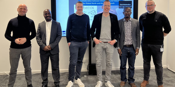 Group picture of all speakers, with the presentation screen in the background.