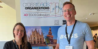Olga Wagner (left) and Uwe Wilkesmann (right) in front of the EGOS poster.