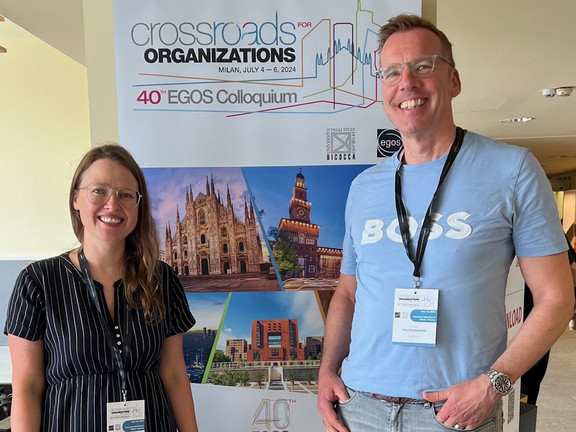 Olga Wagner (left) and Uwe Wilkesmann (right) in front of the EGOS poster.