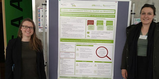 Ronja Vorberg and Olga Wagner next to the poster presented at the conference.